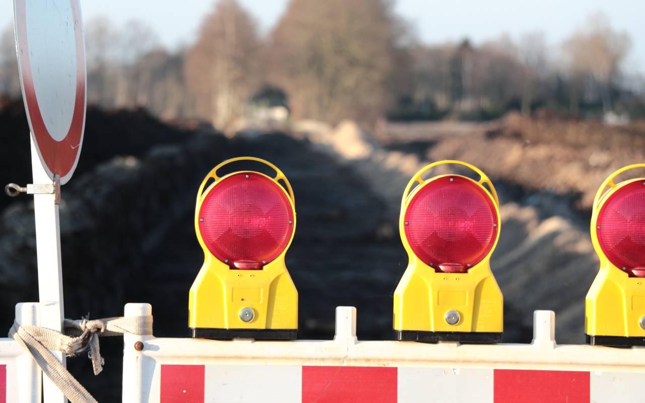 Eine Straßensperre steht im Vordergrund des Bilds, im Hintergrund sieht man unscharf die Baustelle einer neuen Straße.