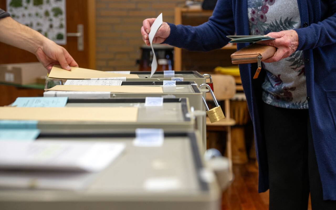 Eine Person gibt seine Stimme bei einer Wahl ab.