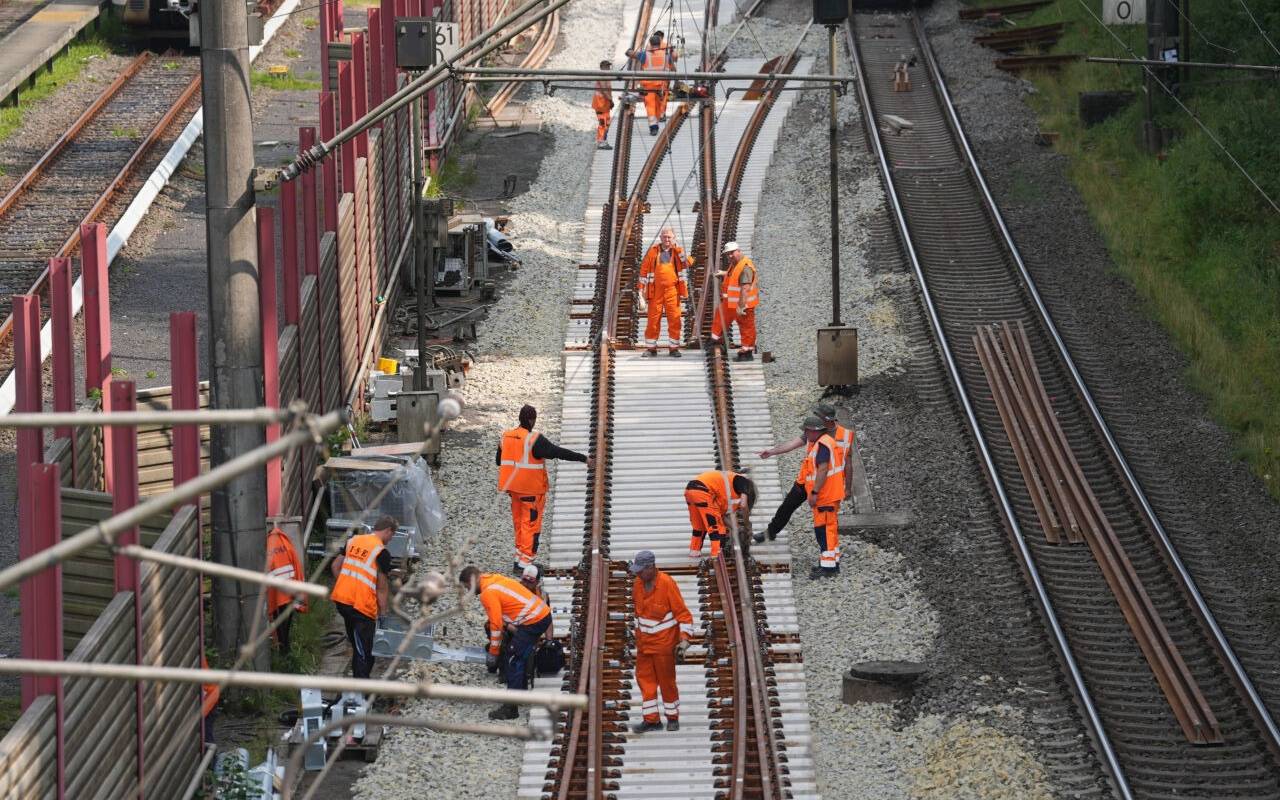 Bauarbeiter führen Sanierungsmaßnahmen an einer Gleisstrecke durch.