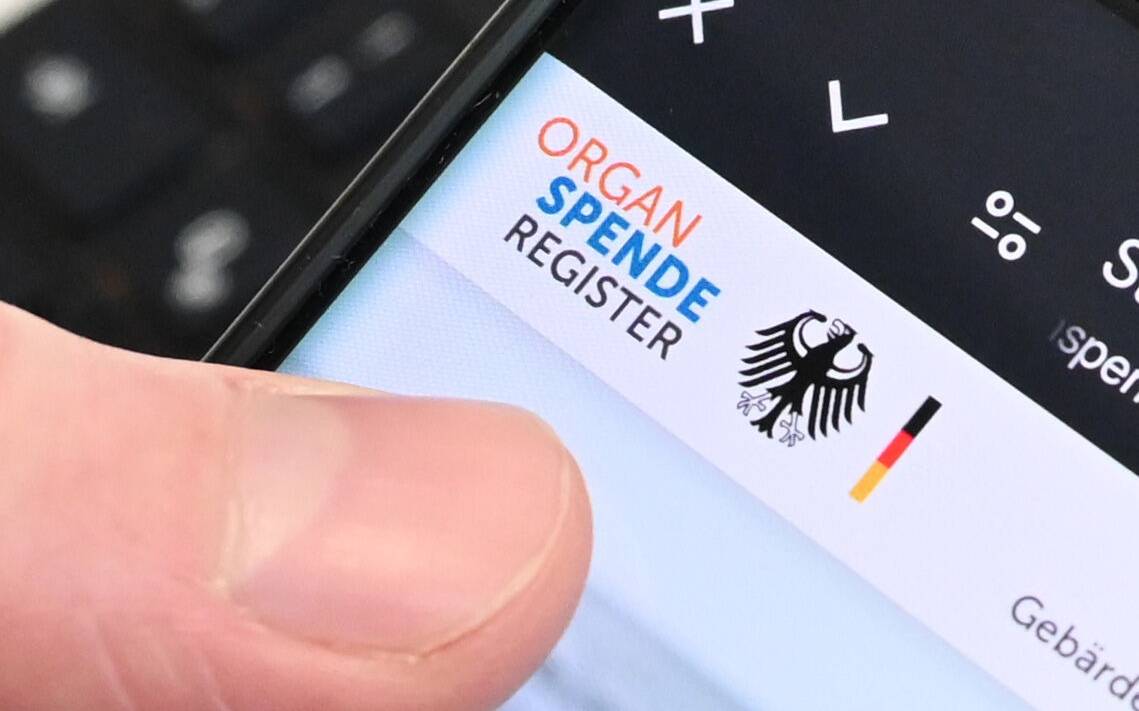 Eine Person hält ein Handy in der Hand, auf dem das Online-Portal zur Registrierung zur Organspende zu sehen ist.