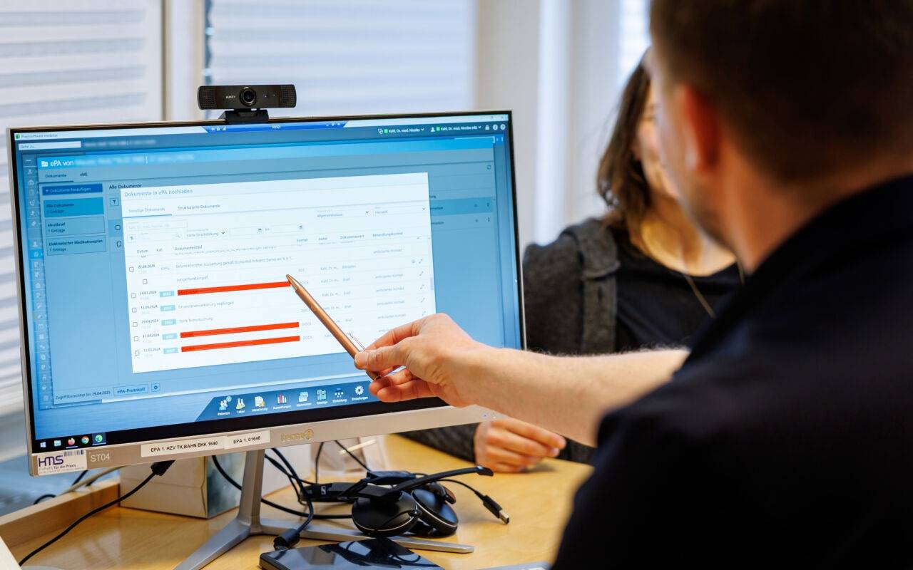 Ein Hausarzt lädt in seiner Praxis Dokumente in eine elektronische Patientenakte
