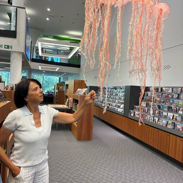 Die Künstlerin Rosanna Baledda steht vor einer ihrer Quallen in der Stadtbibliothek Hattingen
