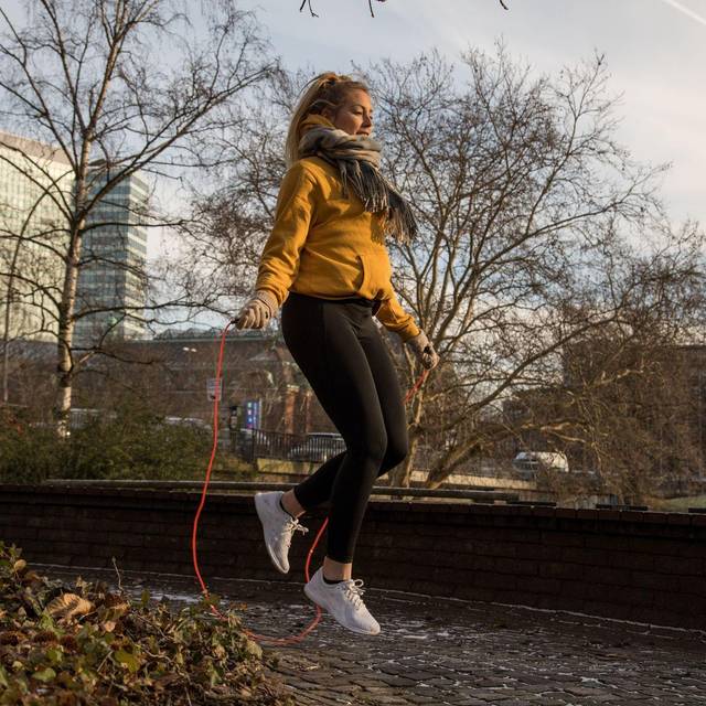 Eine Frau trainiert mit einem Springseil
