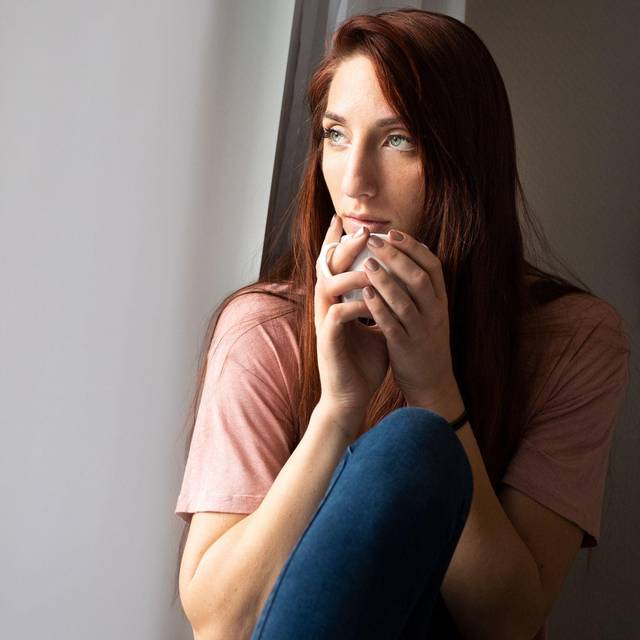 Frau schaut aus Fenster