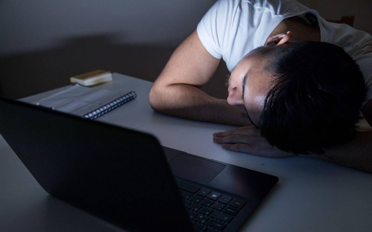 Mann legt erschöpft seinen Kopf auf den Tisch