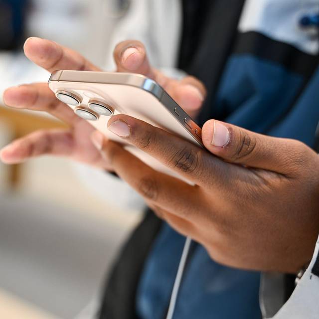 Ein Mann hält ein iPhone 16 in den Händen
