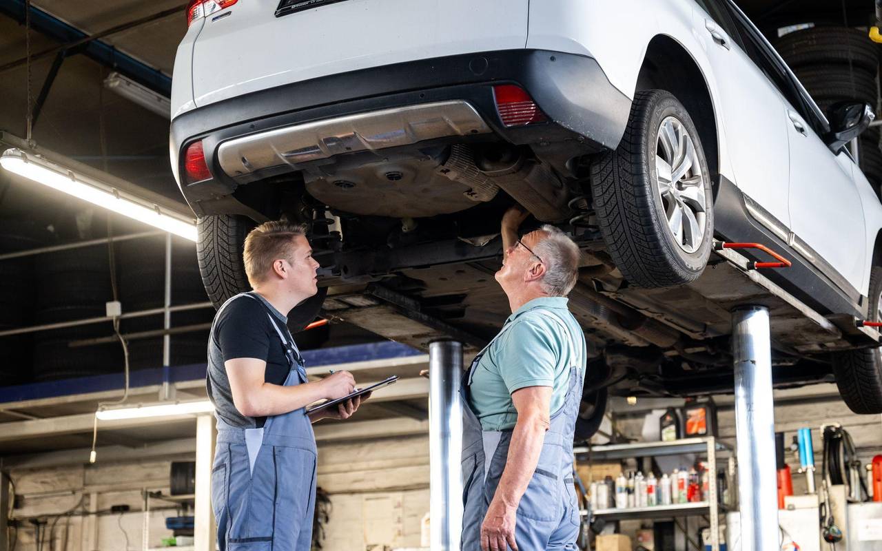 Zwei Männer arbeiten gemeinsam in einer Autowerkstatt