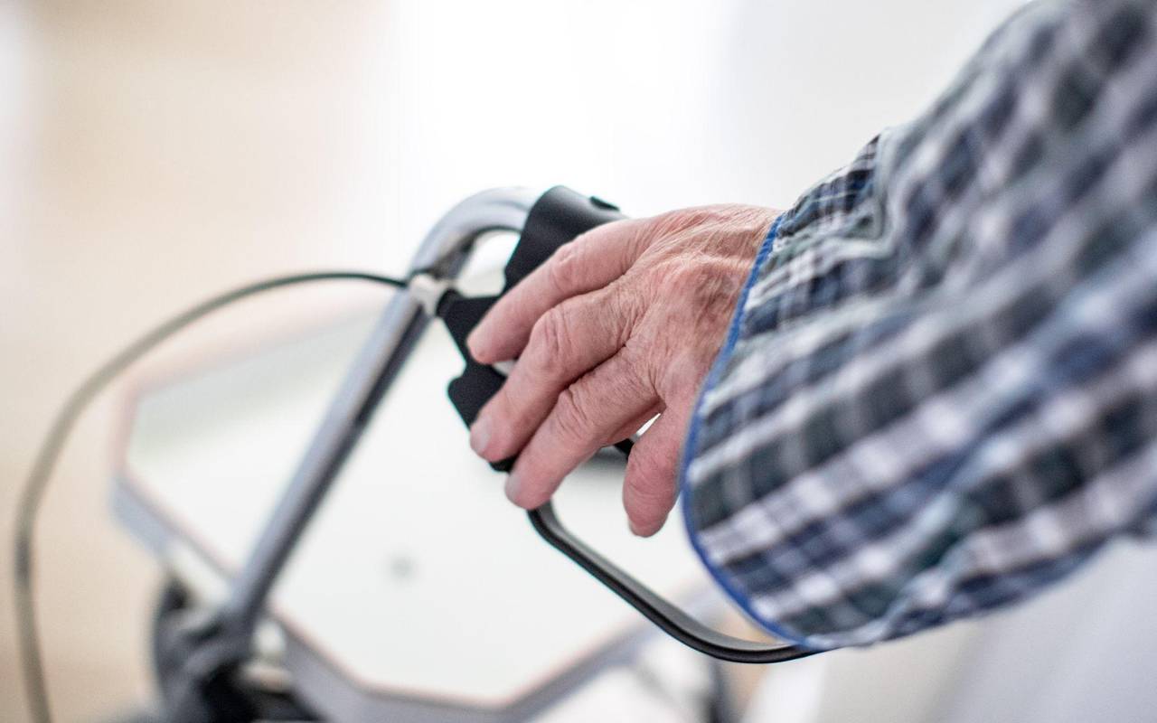 Mann stützt sich auf seinen Rollator