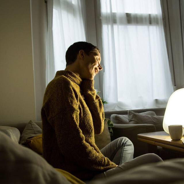 Frau sitzt vor einer Tageslichtlampe