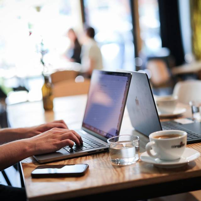 Ein Mensch arbeitet an seinem Computer in einem Café