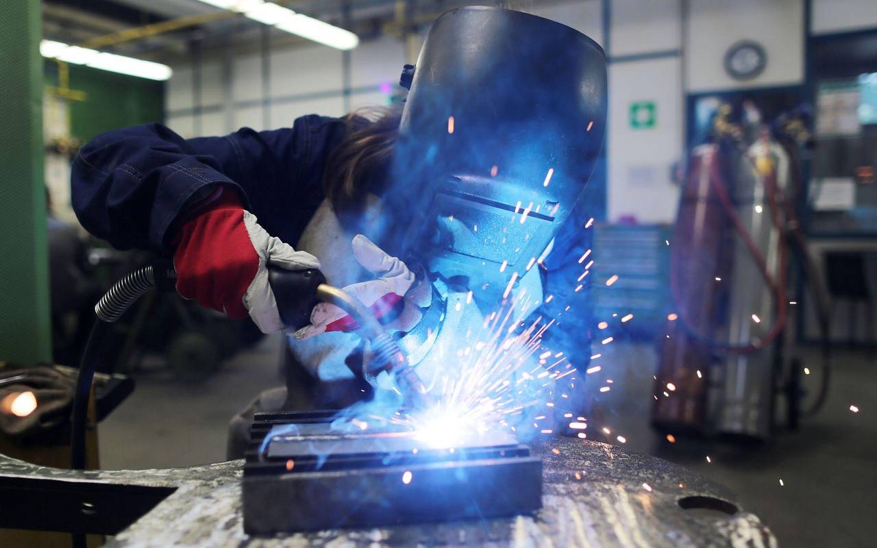 Eine Auszubildende zum Schweißer arbeitet einem Stück Metall