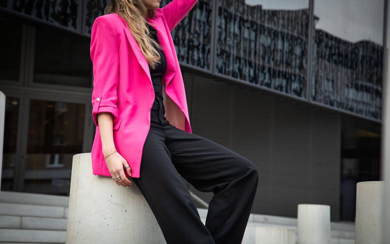 Eine junge Frau trägt einen Neon Pink Blaser