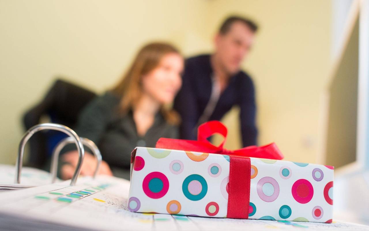 Ein Geschenk liegt auf dem Schreibtisch an einem Arbeitsplatz