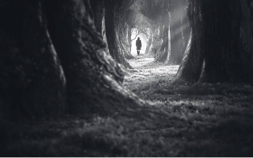 Eine Frau läuft einen einsamen Weg entlang (Symbolbild).