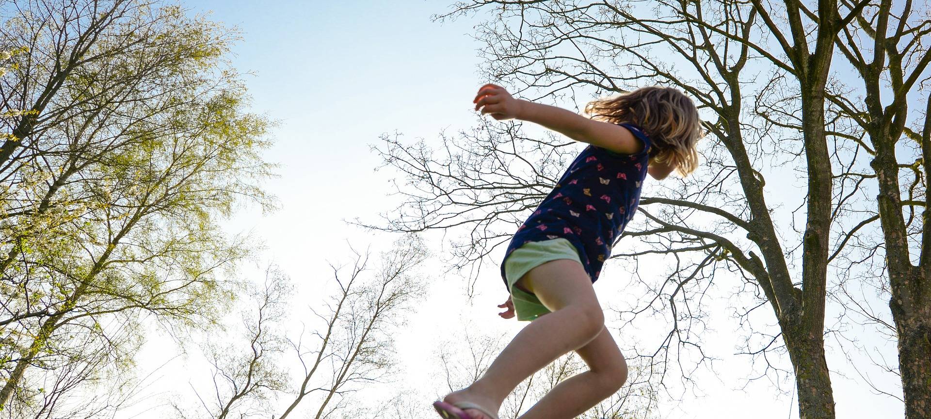 Kind springt auf einem Trampolin.