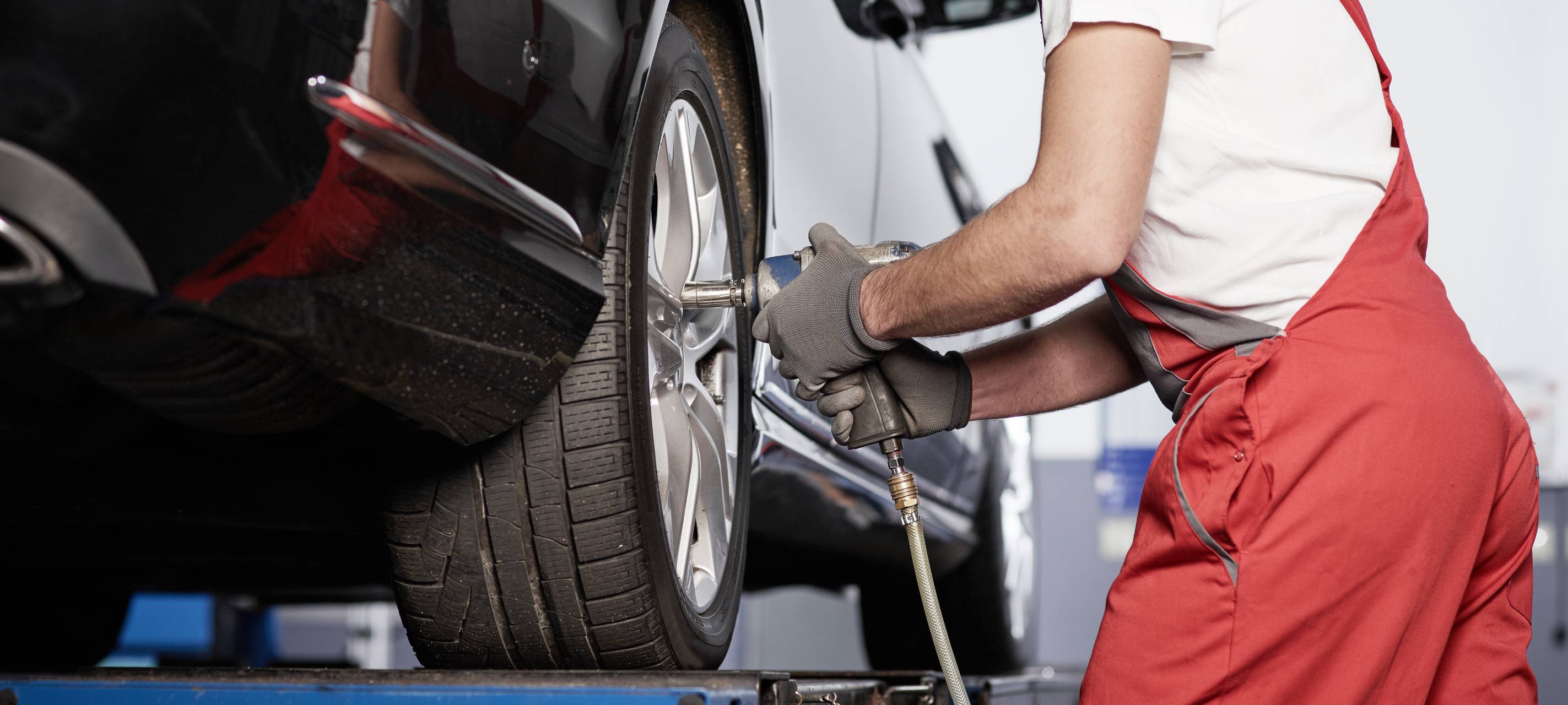 Ein Mechaniker beim Radwechsel (Symbolbild).