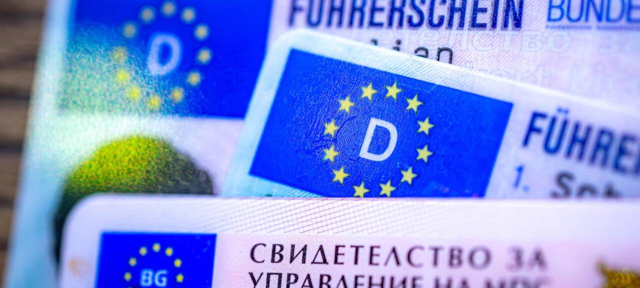 Ein bulgarischer und zwei deutsche Führerscheine liegen auf einem Tisch.