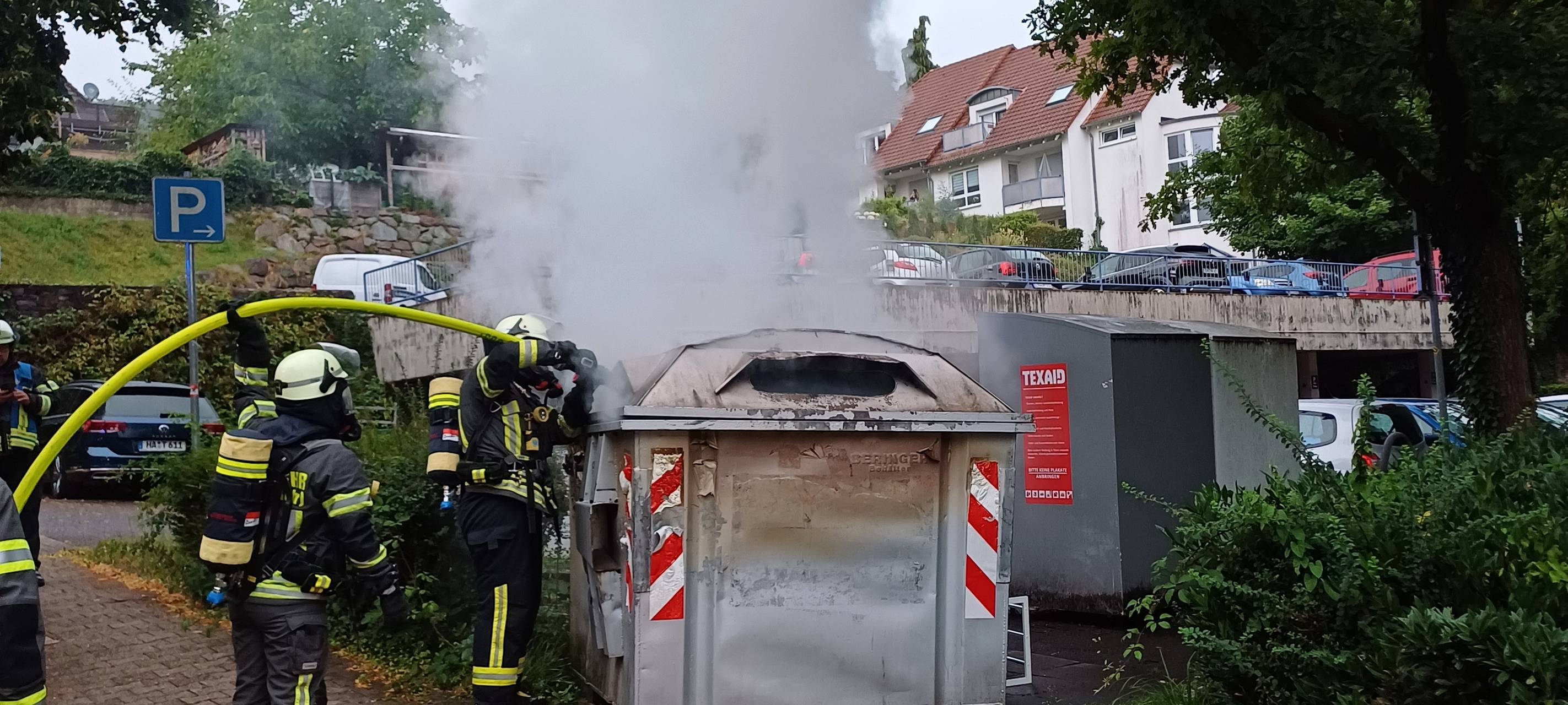 Ein Einsatztrupp der Feuerwehr Wetter löscht einen Containerbrand