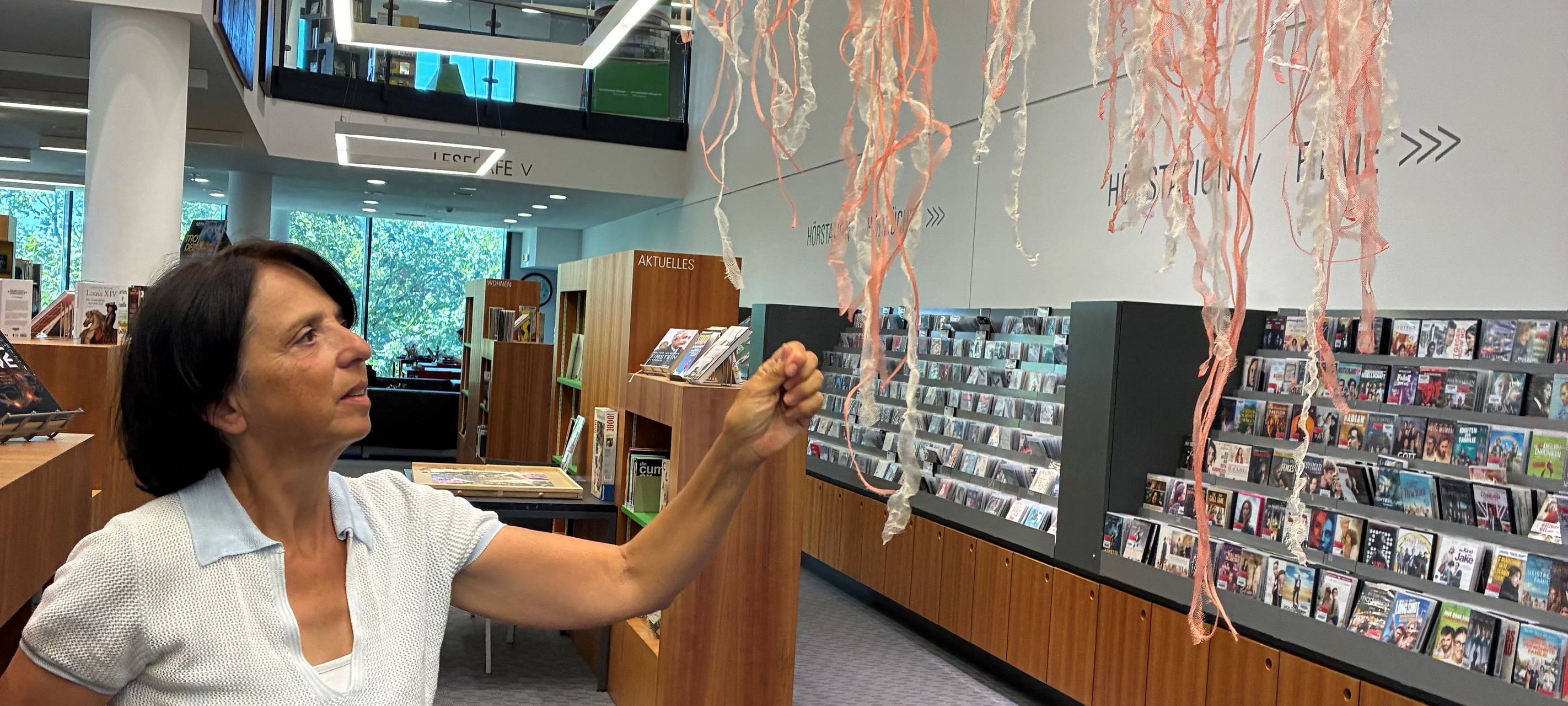 Die Künstlerin Rosanna Baledda steht vor einer ihrer Quallen in der Stadtbibliothek Hattingen