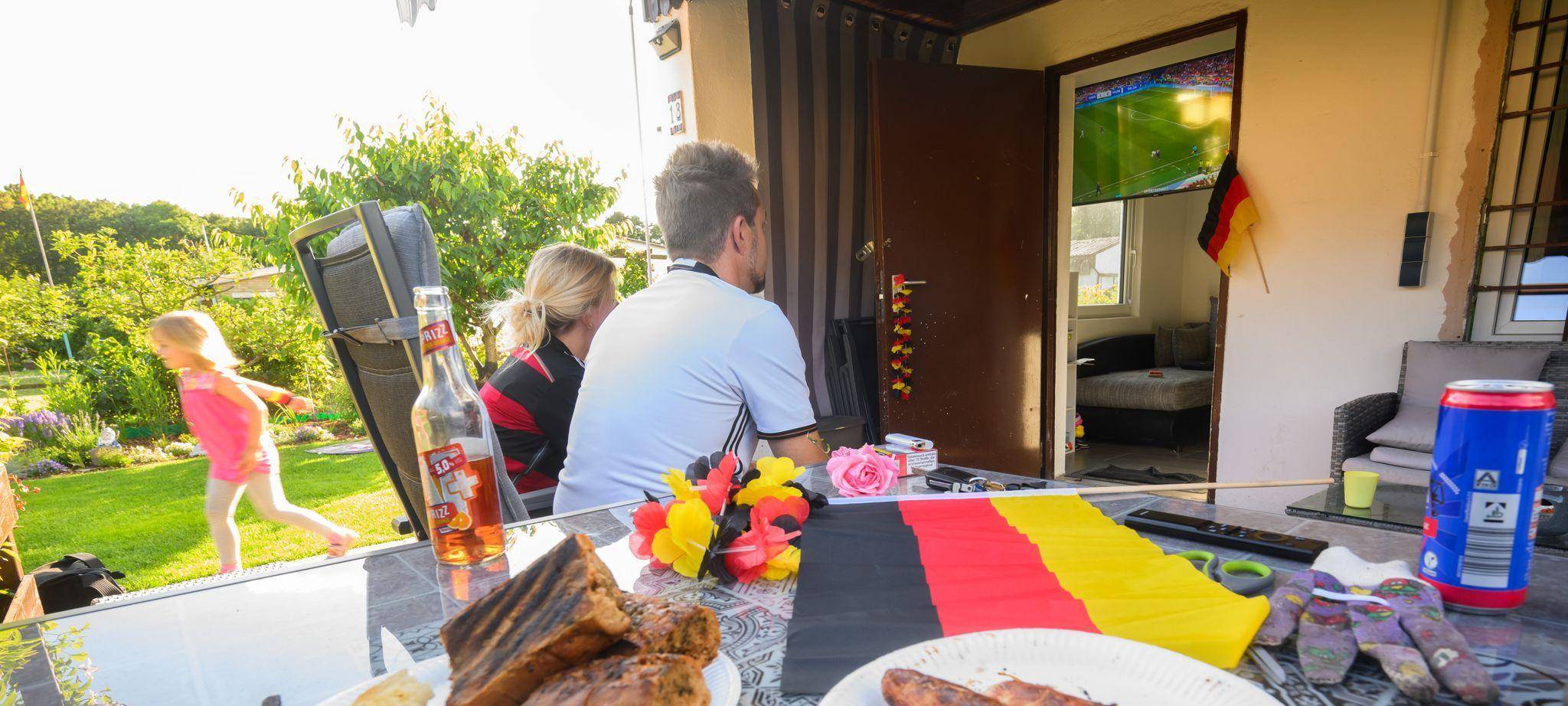 Eine Familie guckt Fußball im Garten