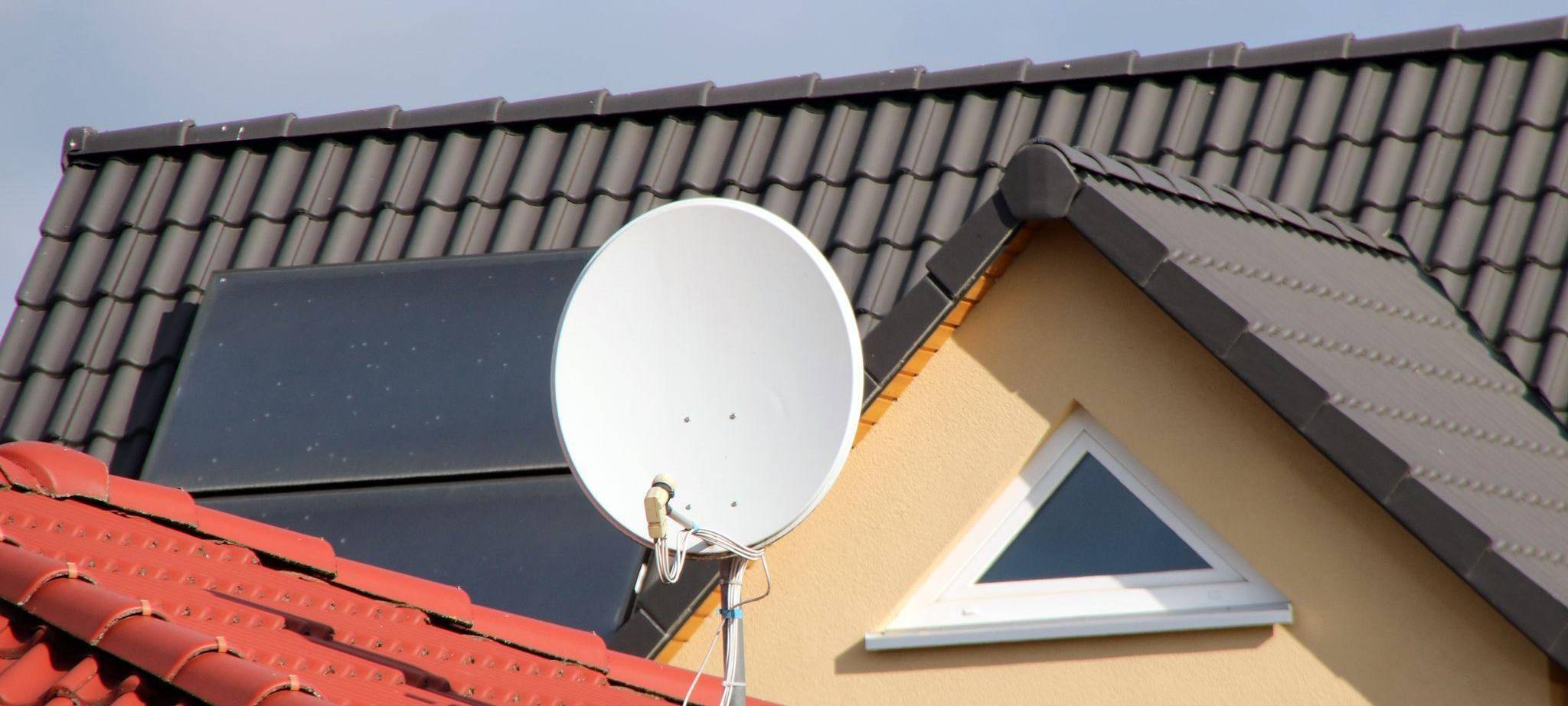 Eine Satellitenschüssel auf einem Hausdach