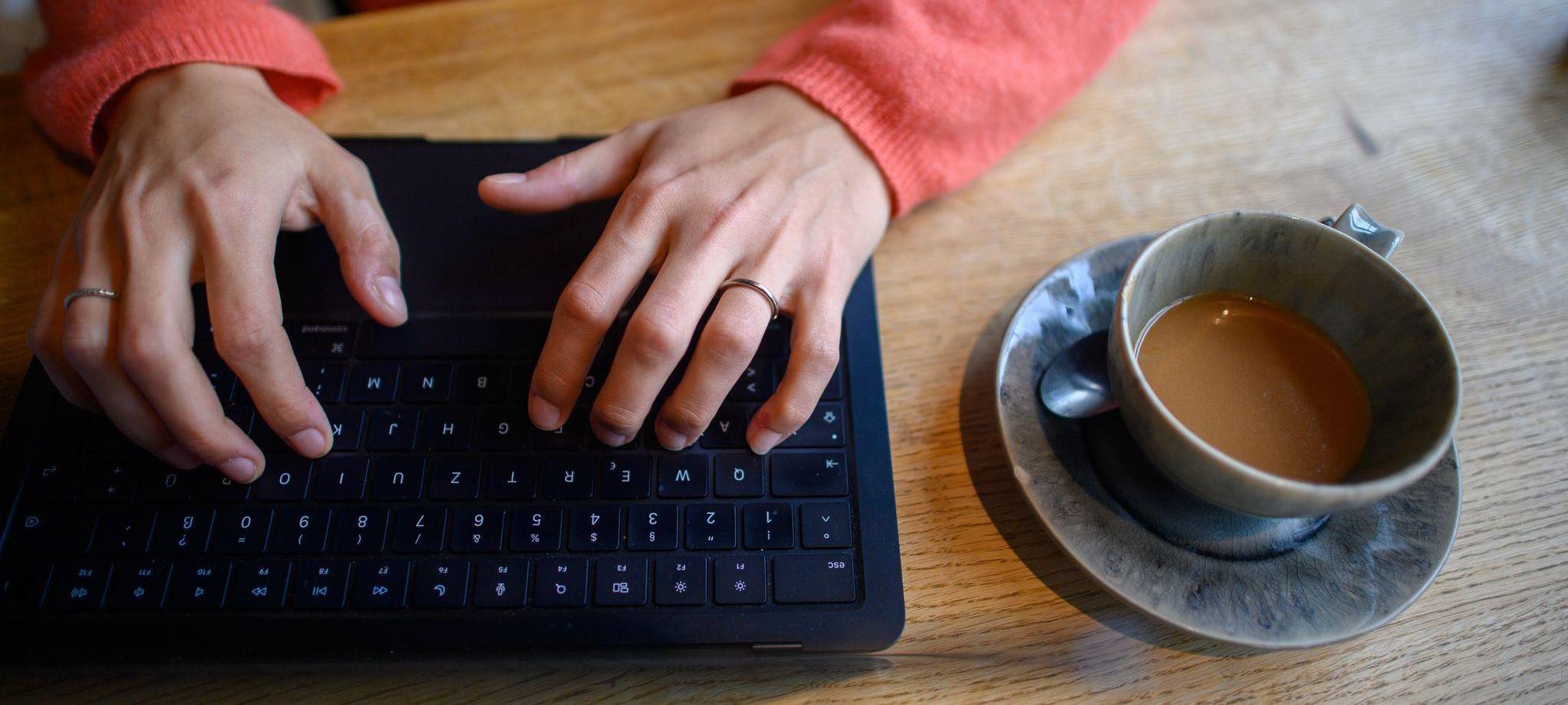 Eine Frau nutzt ihren Laptop in einem Café