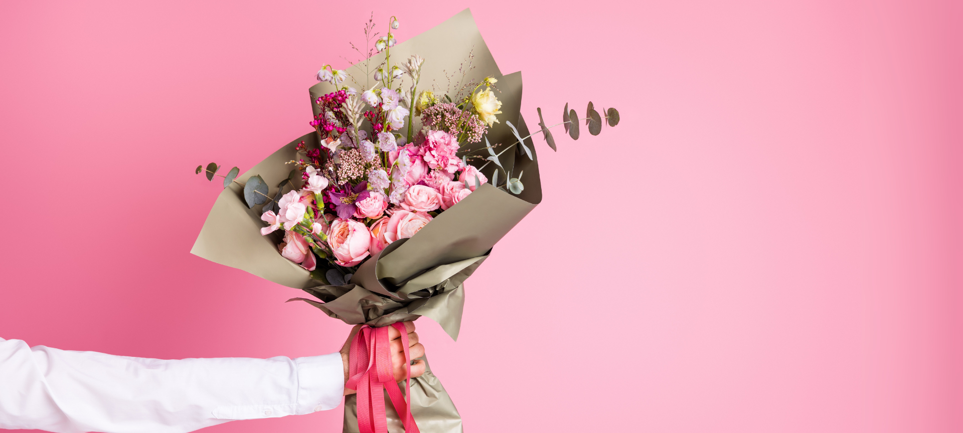 ein fröhlicher Blumenstrauß zum Valentinstag mit rosa Hintergrund