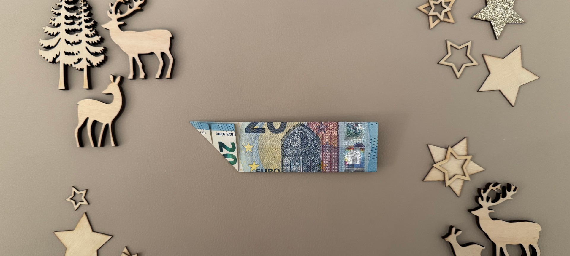 3. Den Geldschein wenden und die linke untere Ecke nach oben rechts falten.